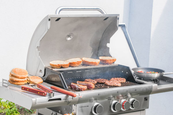 Nerezový plynový gril G21 California BBQ Premium line na zahrade s jidlem