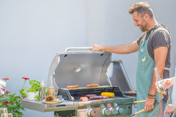 Nerezový plynový gril G21 California BBQ Premium line na zahrade s jidlem