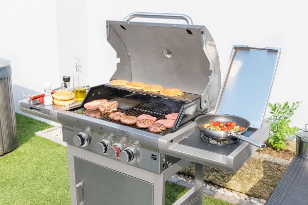 Nerezový plynový gril G21 California BBQ Premium line na zahrade s jidlem